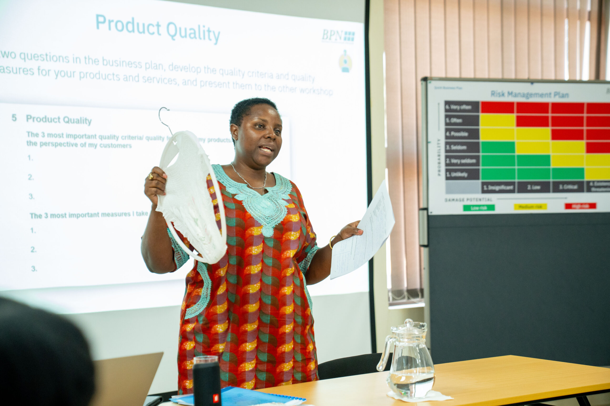 Business training participants presenting in front of a group in Uganda